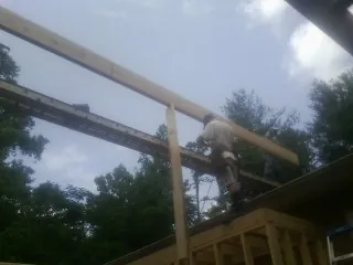 Carpenter setting a ridge beam over a new addition frame — Ice Dam Removal by Roofing Brothers in Maple Falls